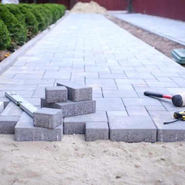 Paving stones pathway paving background. Installing tools on foreground